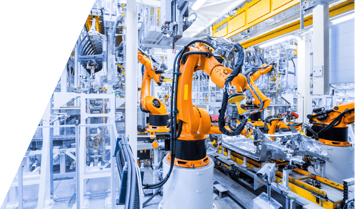 Brazos robóticos naranjas trabajando en una línea de fabricación automatizada.