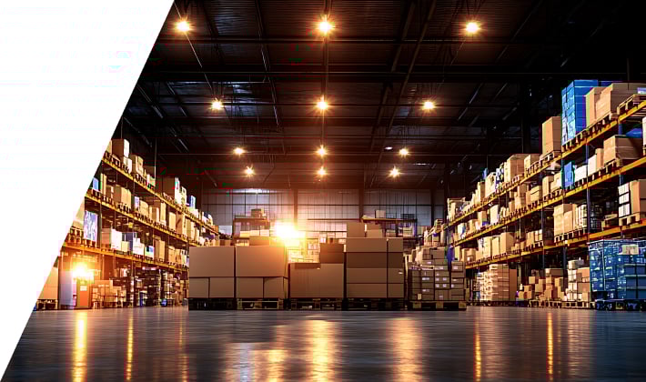 Nave industrial superpoblada con filas de contenedores de productos apilados, que muestran un amplio inventario pero un espacio limitado.